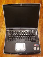 Front view of open HP Pavilion laptop showing keyboard, touchpad, screen, and branding stickers.