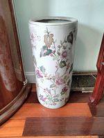 Front view of the tall ceramic cylinder vase with floral vine and leaves design, showing its height and colorfulness.