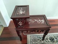 Side view showing two-tier structure with mother-of-pearl inlay on both surfaces, dark cherry rosewood, detailed carving on legs.