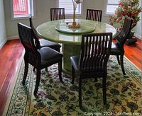 Full view of the floral patterned area rug under a dining table with chairs, showing overall condition and design.