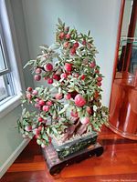 Full view of bonsai tree on wooden stand by window showing overall appearance