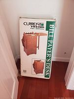 Photo of the unopened box showing the product image and branding for 'Current Trend Bill Payer's Desk'.
