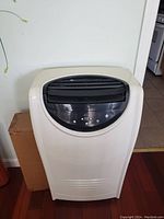 Front view of portable air conditioner showing control panel and air vent louvers.