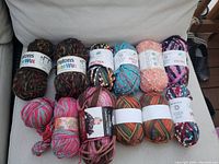 Photo showing multiple skeins of yarn including Patons Orwul and Spectra, various colors and textures.