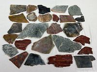 Overhead photo showing all 26 stone specimens arranged on a white background for size and variety display.