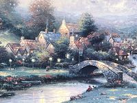 Close-up of canvas print showing village scene with stone bridge and lamplit pathway.