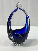 Full view of the cobalt blue and clear glass candy dish, showing basket shape and handle with clear glass top detail.