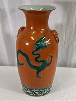 Full front view of vase showing overall shape and green dragon motif on orange-red body