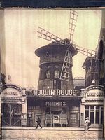 Frontal photo of the vintage sepia toned Moulin Rouge image showing the full windmill facade and signage.