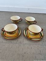 Four cups and two saucers arranged on floor showing pattern and shape