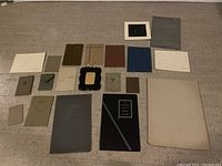 Complete overview of 20 vintage photography cardboard frames and mounts in various sizes and colors, laid out on the floor.