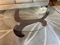Oval glass top and curved wood base front view