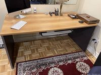 Photo of the entire desk showing wood grain top and black sides, with computer keyboard and lamp on top removed for listing.