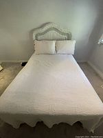 Full bed setup showing the rattan headboard attached to the double bed with white bedding.