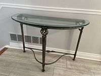 Front side angle showing the half moon glass top and detailed metal frame.