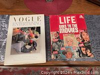 Both coffee table books displayed on a wooden surface side by side, Life Goes to the Movies on the right, Vogue Entertaining on the left