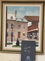 Framed painting showing detailed Montreal street scene, buildings, street lamp, people and market stalls, in a multicolored layered frame.