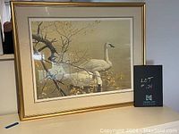 Full image of the framed artwork showing trumpeter swans with branches and leaves in the foreground.