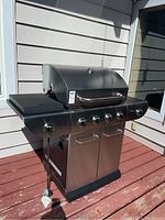 Full front view of grill on deck showing entire unit and side shelves