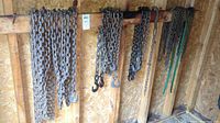 Multiple chains hung on a wooden beam inside a shed