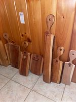 Multiple charcuterie boards of varying heights and widths leaning against a wooden wall