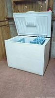 Front view of open chest freezer showing interior and two plastic baskets