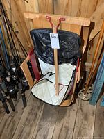 Front view of sleigh showing bentwood runners, wooden slat seat and black vinyl cover pad