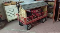 Full view of generator on metal yard cart with wooden shingled cover