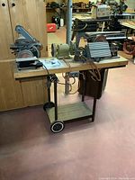 Full view of wheeled cart holding two belt/disc sanders and a bench grinder