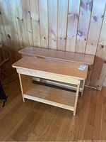 Two wooden benches shown side by side against a wood panel wall, showing size difference and overall condition