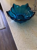 Top and angled view of blue star-shaped glass candy dish showing scalloped edges and textured center.