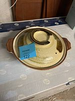 Closed ceramic clay rice pot with lid showing exterior glaze and lid handle.