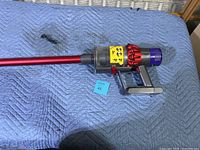 Side view of assembled vacuum showing full length, wand, motor body, dust bin