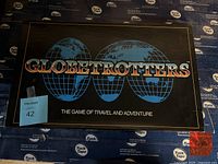 Photo of the Globetrotters board game box showing front design with three blue globes and title.