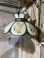 Front and side views of the hanging lamp showing the stained glass floral panels and metal framework.