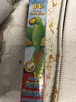 Close-up photo of packaging showing 3D parrot kite design, 84 inch size and branding.