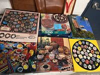 Photo showing all 6 jigsaw puzzles arranged on the floor in their boxes, revealing the variety of themes and piece counts.