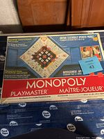 Original Monopoly Playmaster electronic game console in its box, showing the console and board design on top with branding and caution about electricity.