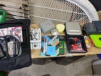 Overview of random lot items arranged on wooden surface and wicker chair arm