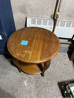 Top view of the round wooden coffee table showing the tabletop with visible wear and a small drawer beneath.