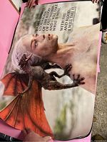Close-up photo of one Game of Thrones poster showing Daenerys with a dragon and an inscription over her head.