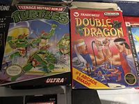 NES Teenage Mutant Ninja Turtles and NES Double Dragon game boxes visible showing condition and artwork with Nintendo branding