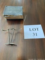 Top-down view of vintage binocular loupe jeweller's glasses and original box on wood surface