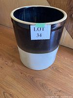 Ceramic pot exterior with Lot 34 tag, showing two-tone brown and beige glazing.