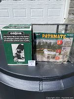 Photo showing the ODJOB hand concrete mixer box and the PATHMATE Belgian Stone path mold side by side on a black surface.