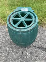 Front and top view of the green rain barrel showing barrel shape and missing cover with open grate top
