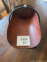 Top view of the inside of the vintage wooden scoop showing the curved wooden body and metal frame.