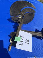 Side view of vintage slicer showing large blade and clamp for attaching to surface.