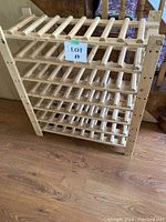 Full view of the wooden wine rack showing its overall shape and size with multiple slatted shelves.