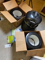 FilterQueen Defender air purifier, two replacement filters in boxes, user manual and wrap on basement floor
